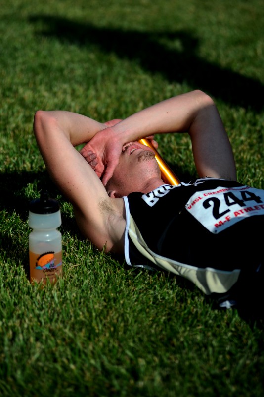 SAM OWENS | The Roanoke Times;  Radford High School student Josh Little rests in the grass after crossing the finish line during the VHSL state track meet at Radford University, Saturday, June 1, 2013. Little and his teammates took the VHSL Boys State Championship title at the meet.