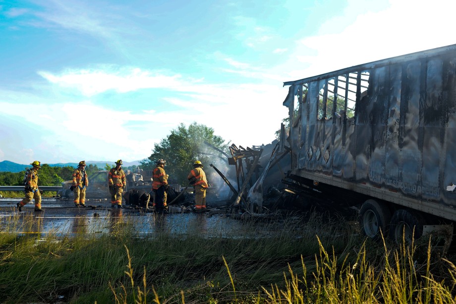 SAM OWENS | The Roanoke Times;  Firefighters run water over the charred vehicles that were involved in the five vehicle wreck, including two tractor-trailers, on Interstate 581, Thursday afternoon, June 12, 2013. Two truck drivers were killed, a few others were injured during the wreck that shut down north and southbound I-581 traffic for several hours.